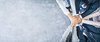 Arme sternförmig angeordnet, deren Hände übereinander liegen